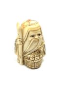 A carved bone Chinese netsuke - Gentleman holding a staff with basket