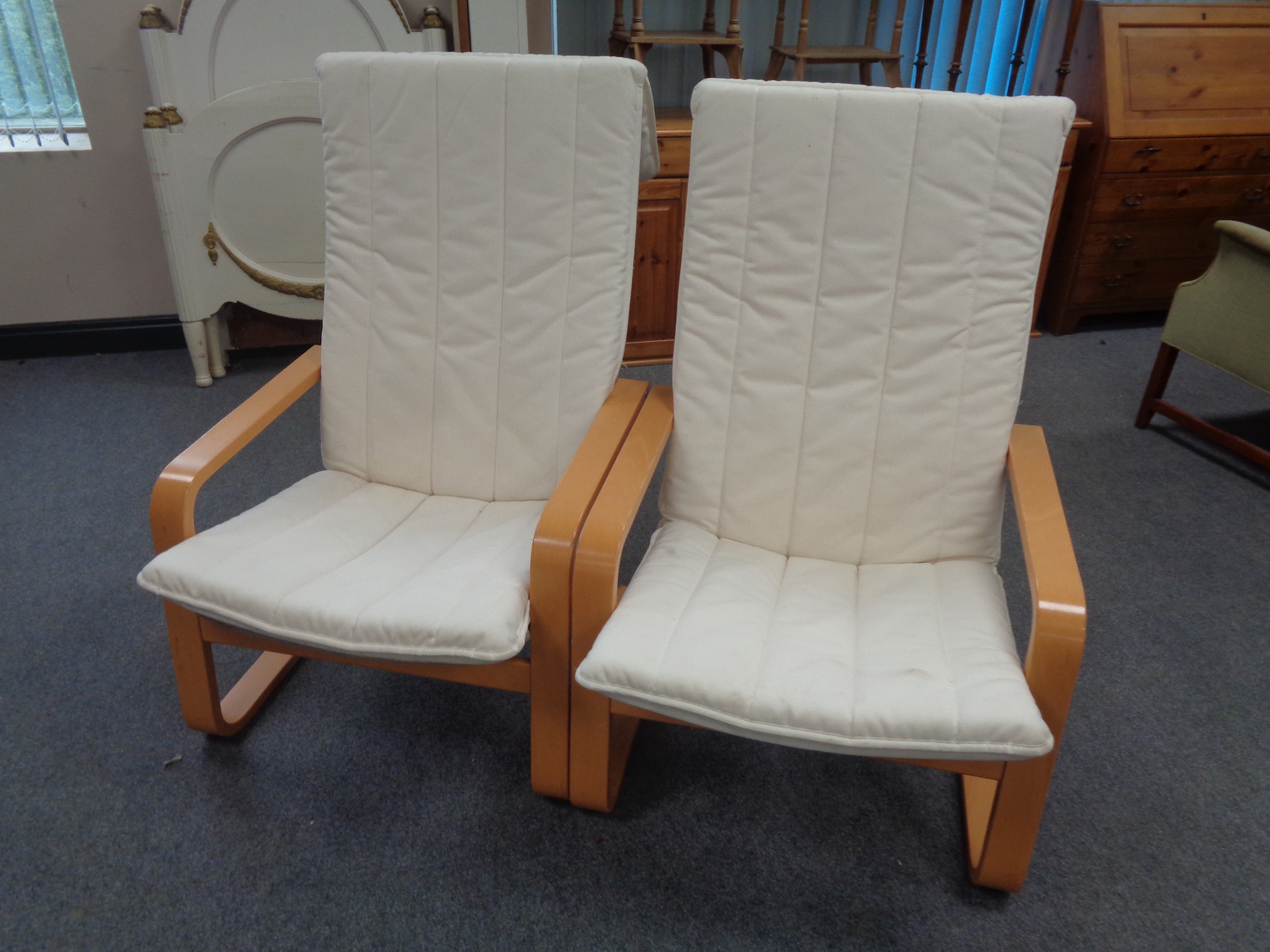 A pair of contemporary beech framed armchairs with cushions