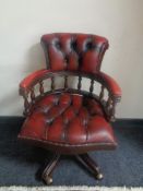 A red buttoned leather swivel captain's desk chair