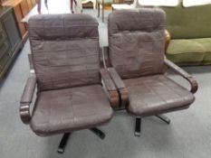 A pair of 20th century stained beech framed swivel armchairs with brown leather cushions