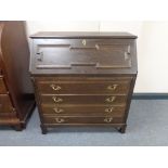 A 20th century writing bureau fitted four drawers with brass mount and handles in an oak finish