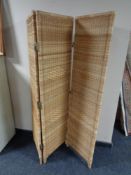 A wicker three way folding screen