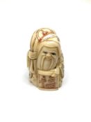 A carved bone Chinese netsuke - Gentleman holding sack