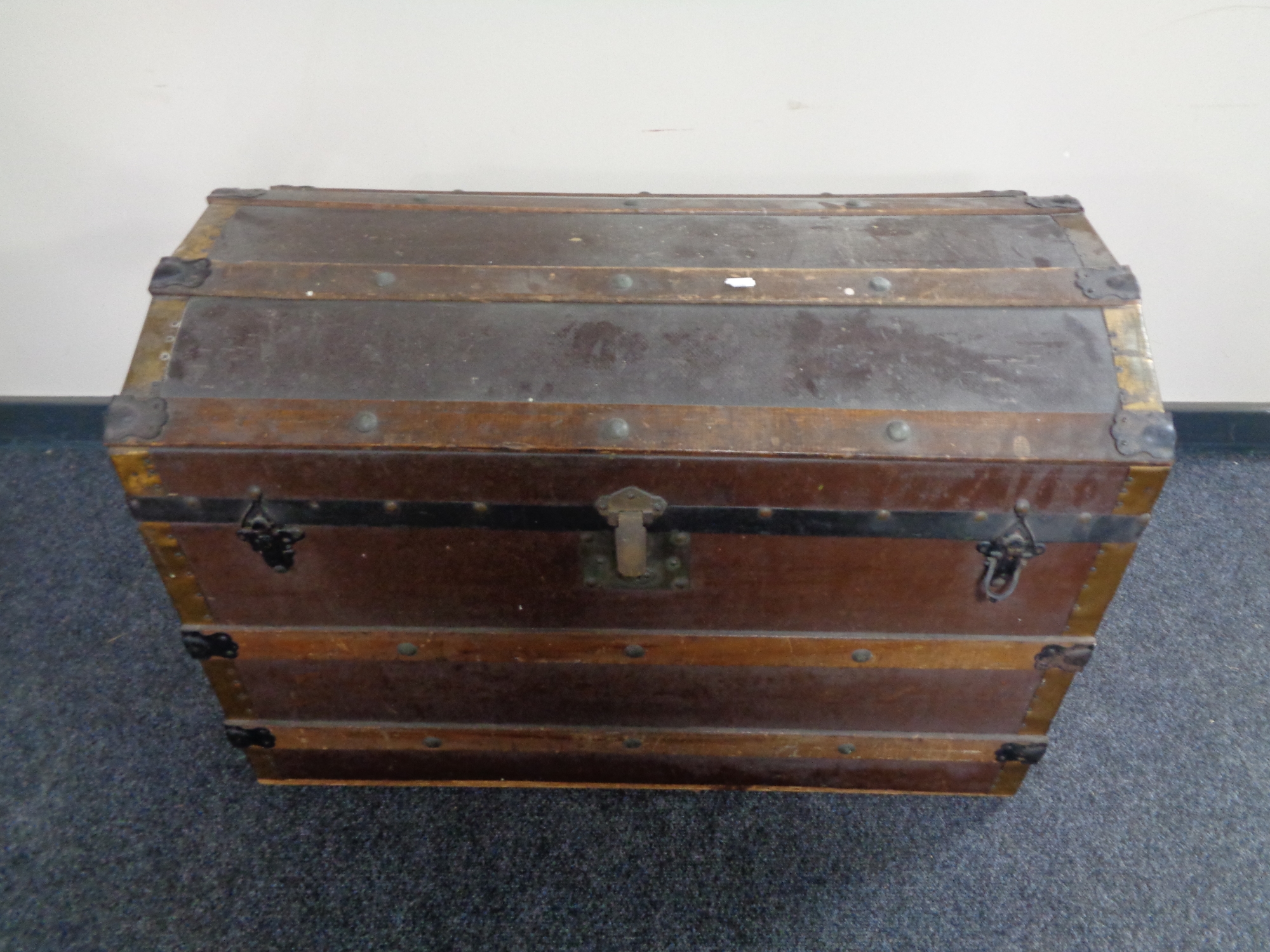 An early 20th century wooden bound dome topped shipping trunk