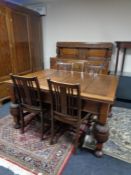 An early 20th century heavily carved oak six piece dining room suite comprising of buffet back