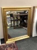 A contemporary golden framed mirror 87 x 102 cm