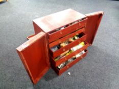 A seven drawer stained plywood fly maker's cabinet containing fly making equipment