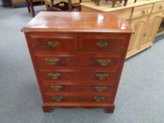 A Georgian style six drawer chest with brass drop handles in a mahogany finish