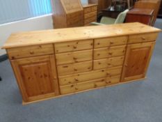 A contemporary pine sideboard fitted two cupboards and ten drawers