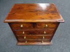 A reproduction hardwood five drawer miniature chest