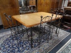 A South African Knysna Furniture hardwood dining table on wrought iron legs together with a set of
