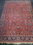 A machine made Persian design carpet on red ground,