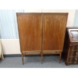 A mid 20th century double door cabinet on raised legs