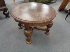 A circular carved coffee table on bulbous legs