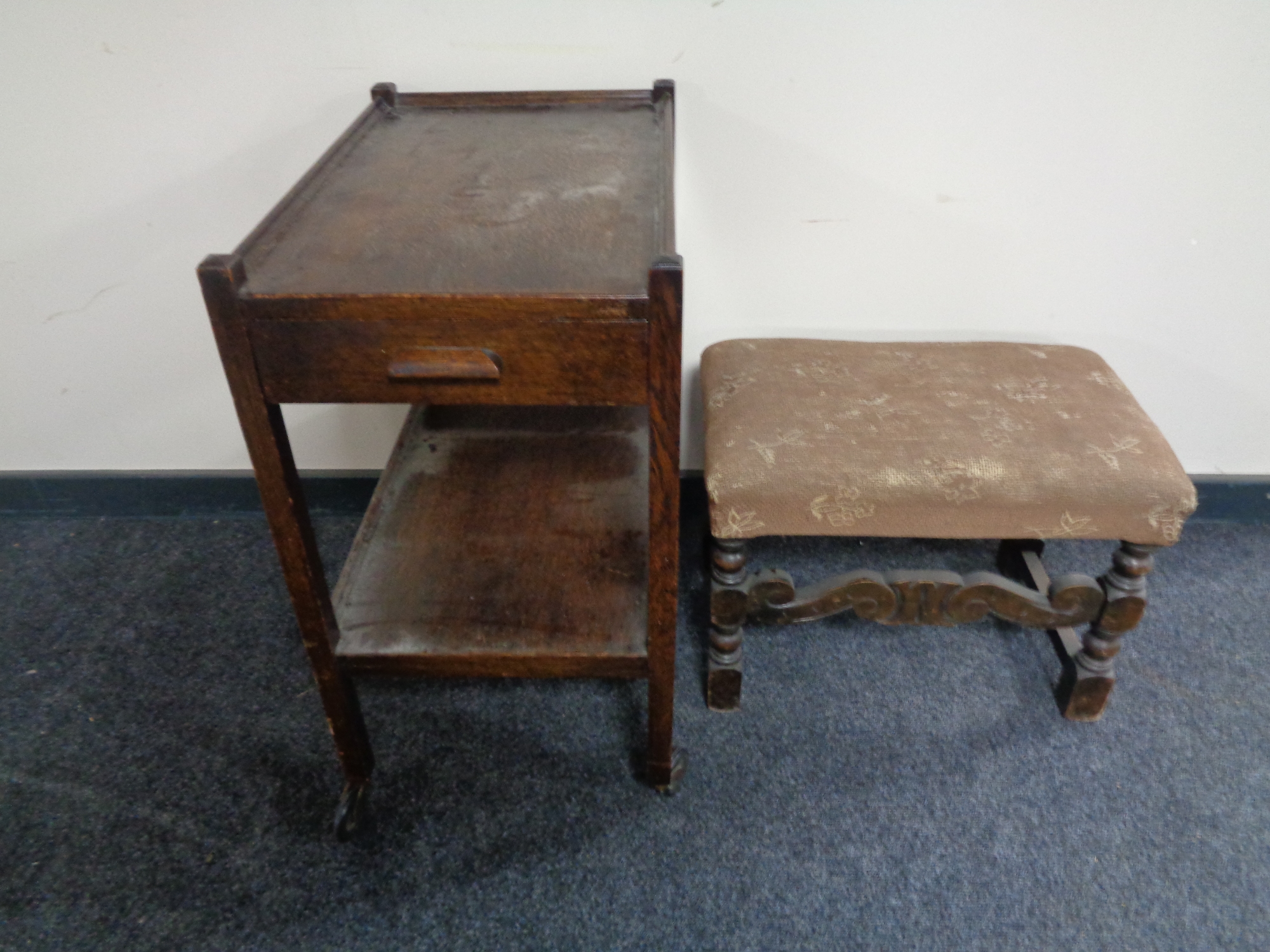 A carved oak upholstered stool together with a two tier tea trolley