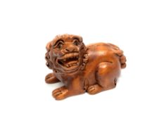 A carved hardwood Chinese netsuke - Lion seated