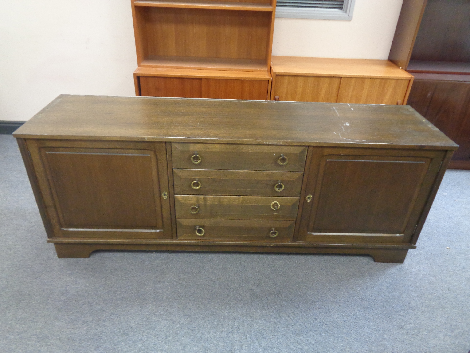 A double door low sideboard fitted four central drawers in an oak finish