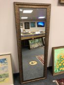 A golden ribbed framed mirror 59 x 153 cm