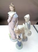 Three Nao figures, girl with doll, girl with basket,