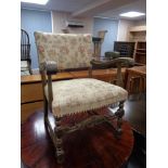 A carved armchair upholstered in a floral tapestry fabric