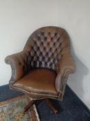 A brown buttoned leather Chesterfield style swivel high back armchair CONDITION REPORT: