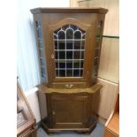 A 20th century corner cabinet with leaded glass doors,