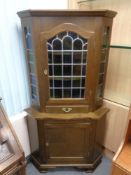 A 20th century corner cabinet with leaded glass doors,