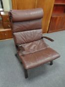 A 20th century stained beech framed armchair with brown leather cushion