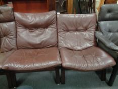 A pair of 20th century stained beech low back relaxer chairs with brown buttoned leather cushions
