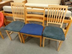 A pair of contemporary rail back dining chairs together with a ladder back chair
