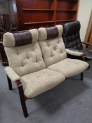 A 20th century stained beech two seater settee upholstered in a beige buttoned fabric