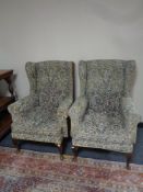 A pair of tapestry upholstered wingback armchairs on Queen Anne legs