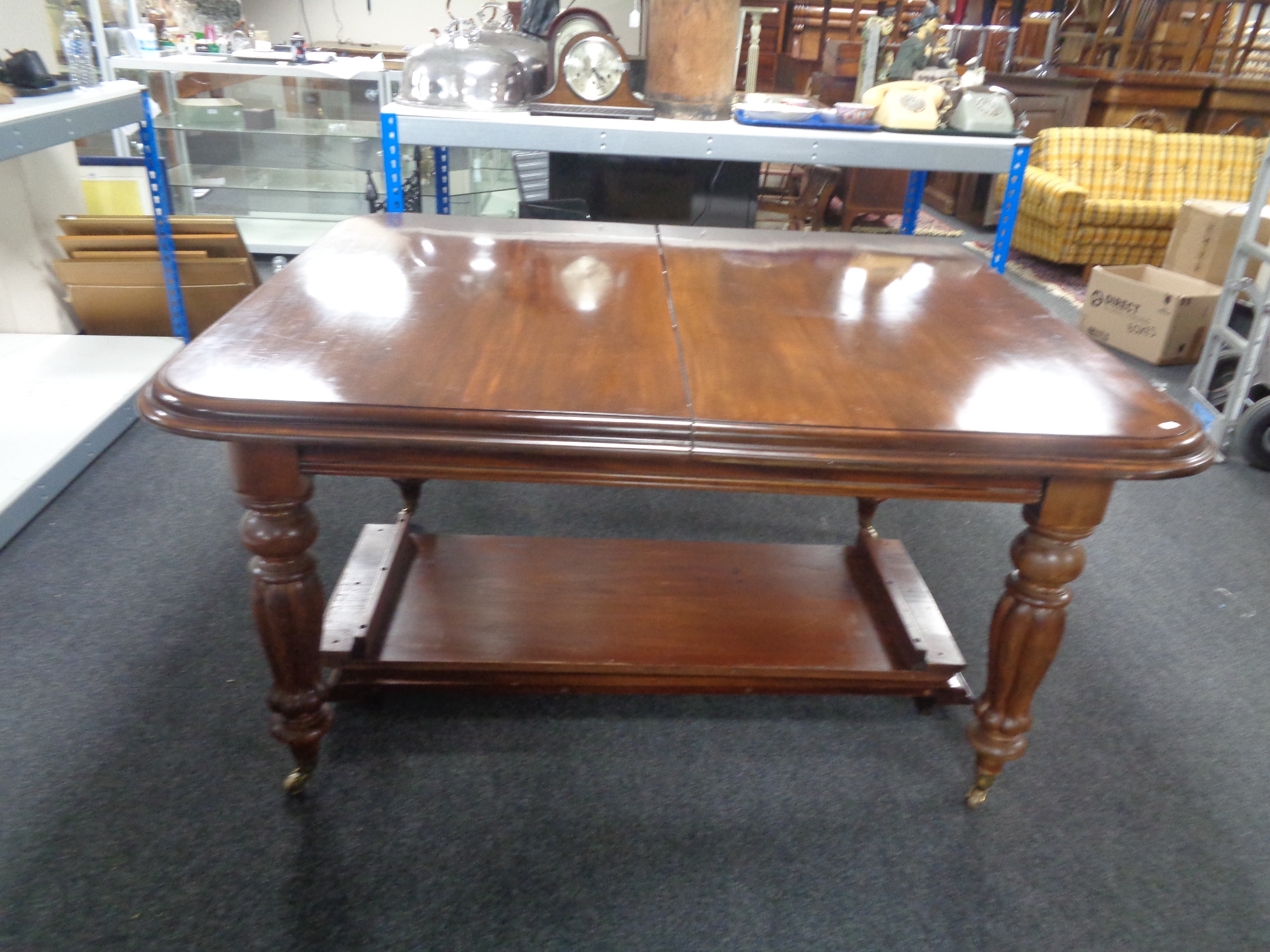 A Victorian style mahogany wind out dining table with two leaves