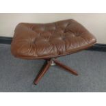 A 20th century brown button leather footstool on four way pedestal