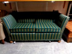 A 20th century continental drop side settee upholstered in a green striped fabric