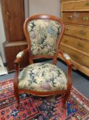 A beech framed armchair upholstered in a floral tapestry fabric