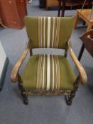 A 20th century scroll arm armchair upholstered in a green striped fabric