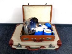 Two vintage luggage cases containing studio pottery four piece tea service,