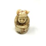 A carved Chinese bone netsuke - Figure holding a sack on back