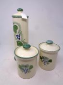 Three Poole pottery lidded storage jars hand-painted with grape design