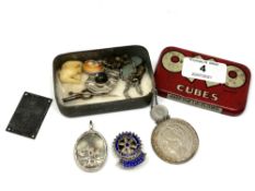 A small Oxo tin containing silver mounted pendant, silver Rotary Hexham badge, coin,