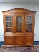 An Italian style arch topped triple door display cabinet, fitted cupboards beneath.