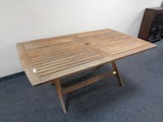 A teak garden table on X-frame support CONDITION REPORT: 170cm long by 100cm wide