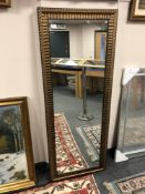 A golden ribbed framed mirror 59 x 153 cm