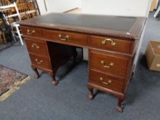 An Edwardian mahogany twin pedestal desk fitted seven drawers with brass drop handles,