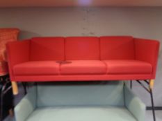 A 20th century three seater settee upholstered in a red fabric (patched).