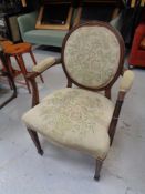 An antique continental armchair upholstered in a floral tapestry fabric