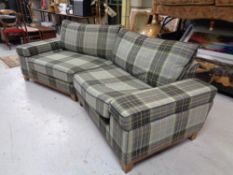 A V-shaped settee upholstered in a checked fabric