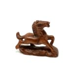 A carved Chinese hardwood netsuke - Cantering foal