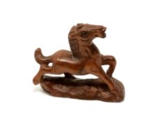 A carved Chinese hardwood netsuke - Cantering foal